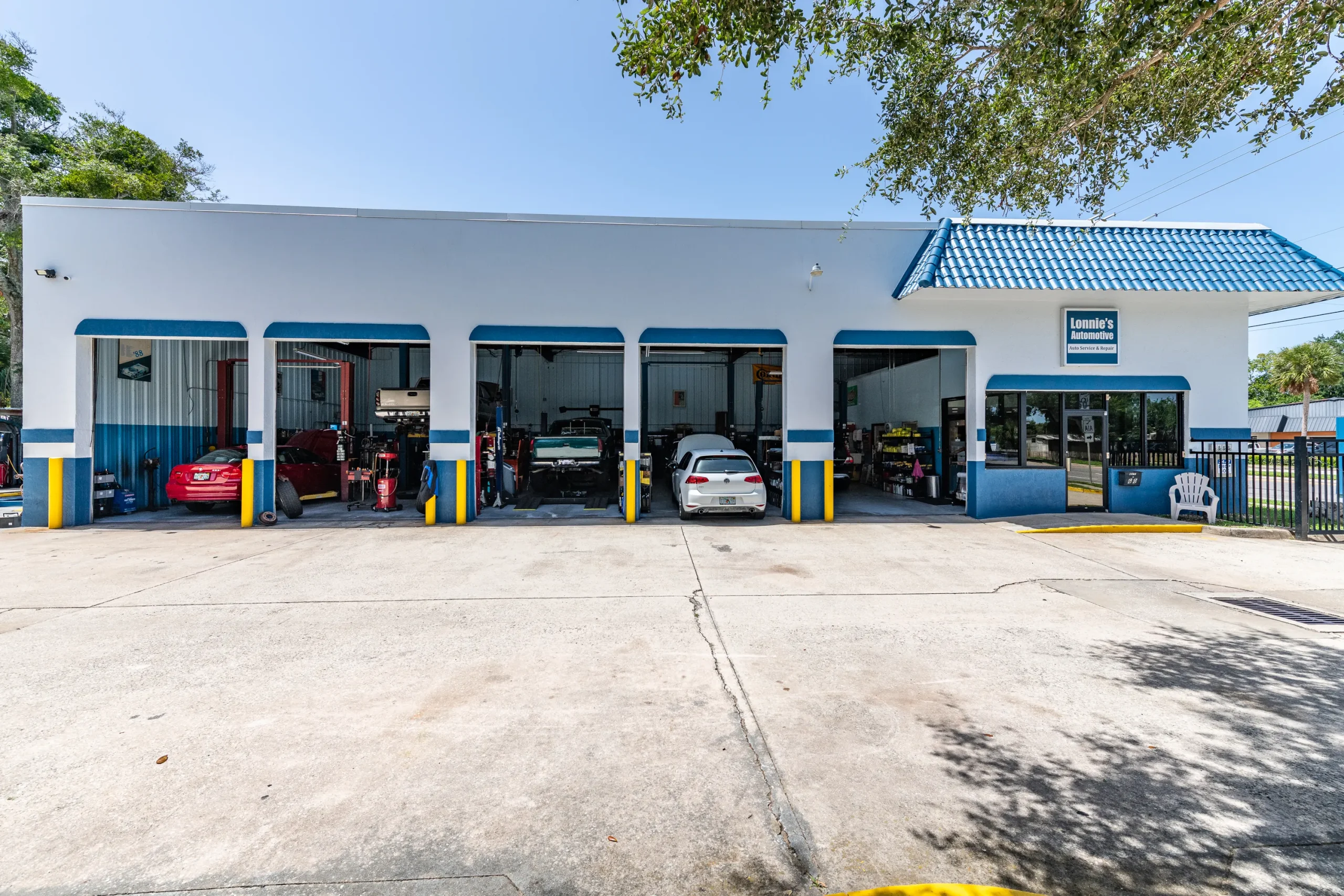 Exterior of the auto shop with service bays open