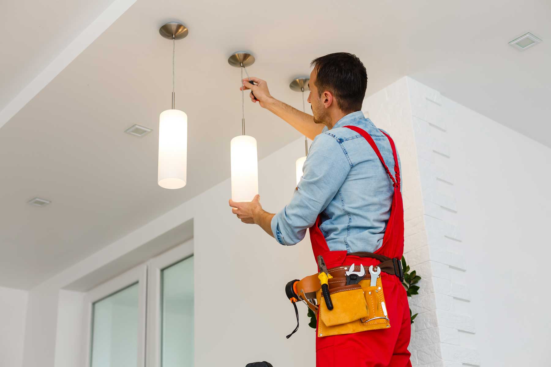 Electrician installing recessed or pendant lighting